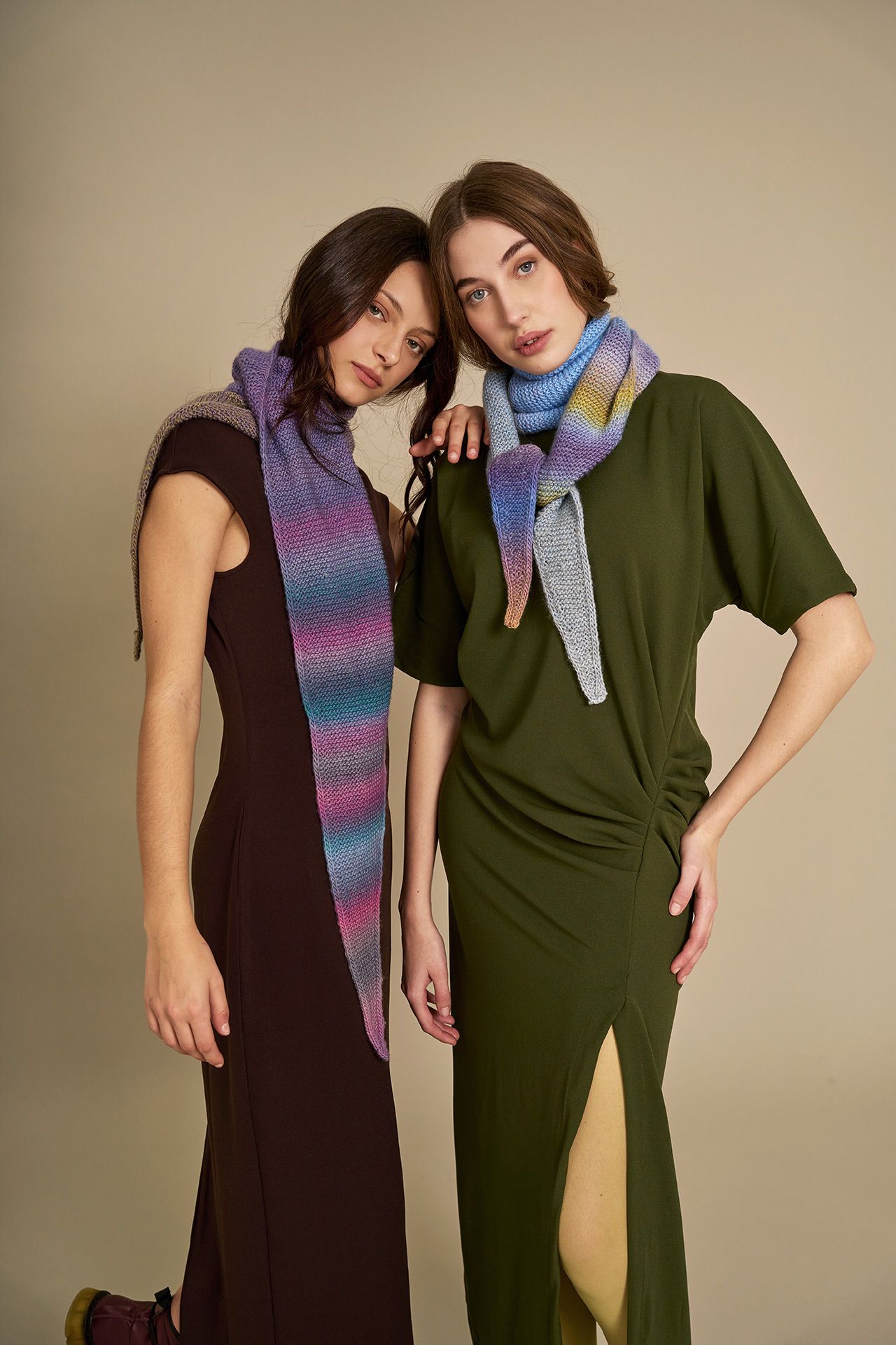 Zwei Frauen mit langen gestrickten Schals aus Poema Color Wolle, Farbverlauf Lila-Rosa-Türkis und Pastellblau-Lila-Gelb – hochwertige Wolle in Hamburg kaufen.