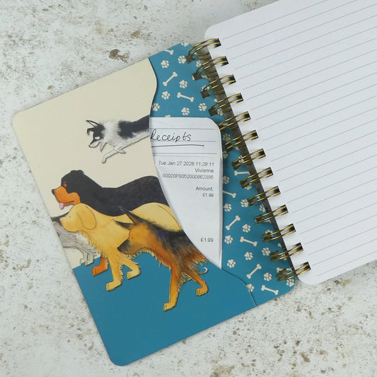 Innentasche des „Paw Club" Notizbuchs mit einer eingesteckten Quittung. Petrolblaues Innenmuster mit Pfoten und Knochen. Aquarell-Illustration von Eric Heyman: Berner Sennenhund, Golden Retriever, Schäferhund und springender Hund.