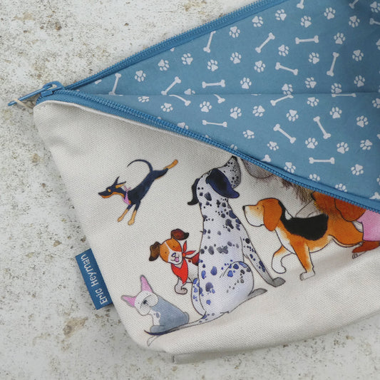 Geöffnete „Paw Club" Reißverschlusstasche von Eric Heyman mit blauem Futter mit Pfoten- und Knochen-Muster. Außenseite mit Aquarell-Illustration verschiedener Hunde.