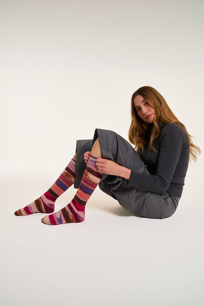 Model mit handgestrickten Ringelsocken aus 6 Ply Optical Socks in Rot und Violett