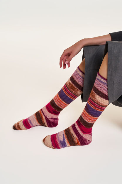 Handgestrickte Socken aus 6 Ply Optical Socks in Rot und Violett, am Model getragen
