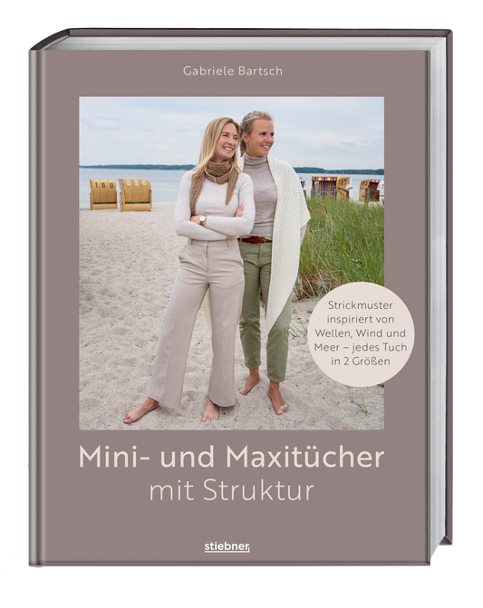 Buchcover von „Mini- und Maxitücher mit Struktur" von Gabriele Bartsch — zwei Personen am Strand mit Strandkörben im Hintergrund, eine trägt ein kleines Halstuch, die andere ein großes weißes Strukturtuch; Verlag Stiebner, taupefarbener Einband.