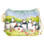 Projektbeutel „Seathrift Puffins" von Emma Ball auf weißem Hintergrund — Baumwollbeutel mit Kordelzug, bedruckt mit sechs Papageientauchern zwischen rosa Strandnelken vor grüner Küstenlandschaft; grün-weiß gestreiftes Innenfutter sichtbar am Rand.