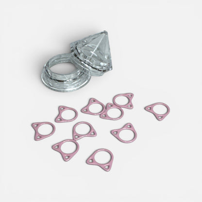 Zehn Maschenmarkierer in Katzenform mit zwei Öhrchen, daneben eine Dose in Diamantform aus klarem Kunststoff.