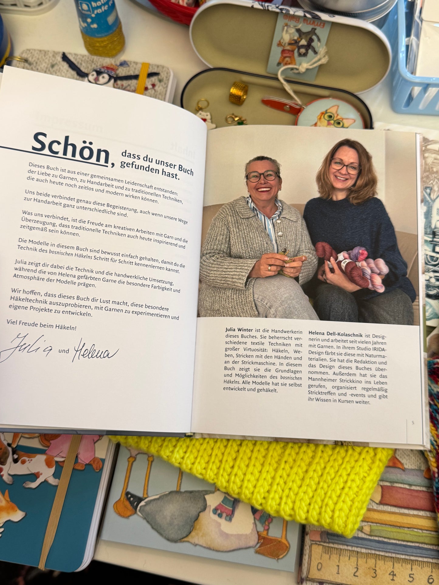 Aufgeschlagene Buchseite mit Porträts der Autorinnen — Julia Winter mit Häkelarbeit in den Händen, Helena Dell-Kolaschnik mit bunten Garnsträngen; kurze Biografien beider Autorinnen sichtbar.