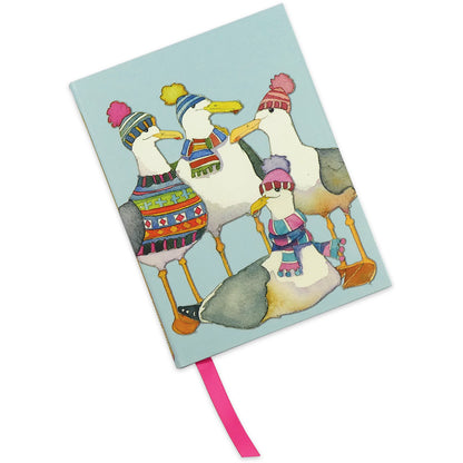 Geschlossenes Notizbuch „Gulls in Beanies" von Emma Ball — hellblauer Einband mit vier Möwen in Bommelmützen und Strickpullovern, rosa Lesebändchen sichtbar.