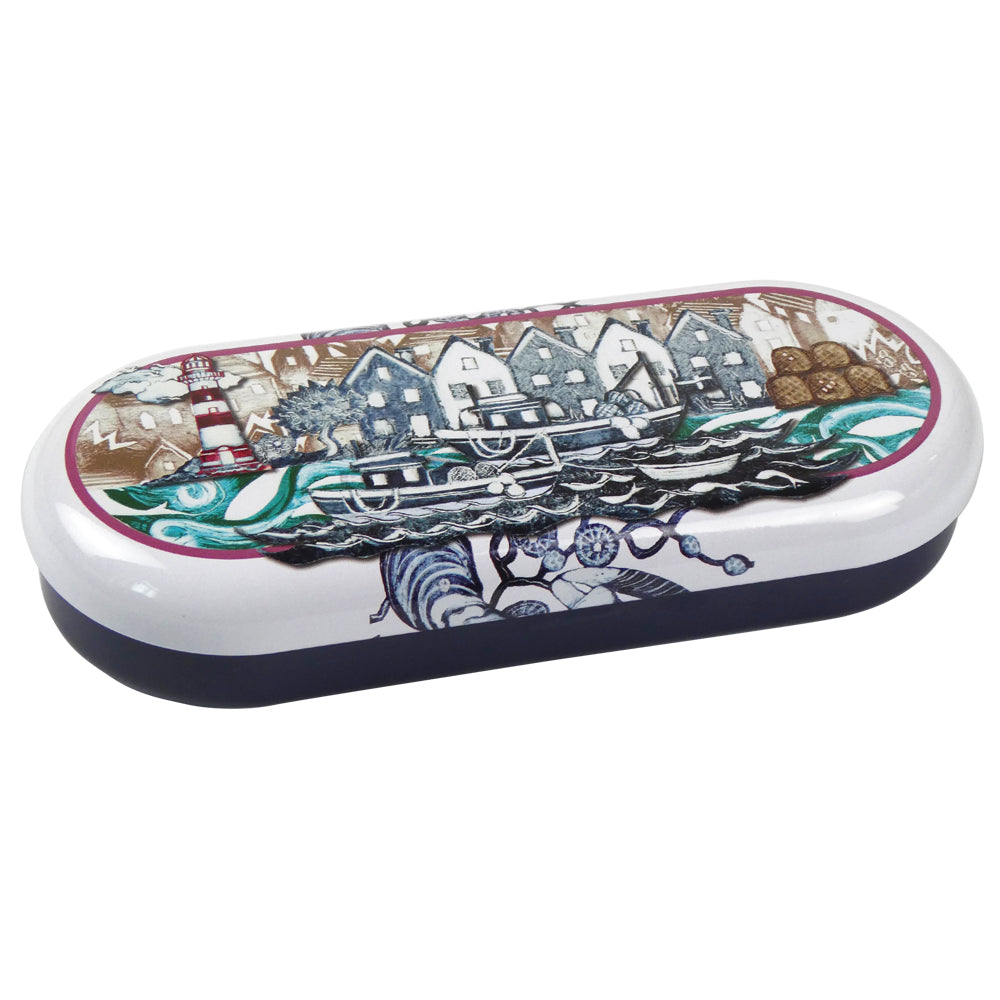 „Fishing Village" Etui von Caroline Cleave, geschlossen. Cremefarbene Oberseite mit dunkelblauer Schmalseite. Linolschnitt-Illustration: Hafendorf mit weißen Häusern, rot-weißer Leuchtturm, Fischerboote auf bewegtem Wasser, Hummerkörbe am Ufer.