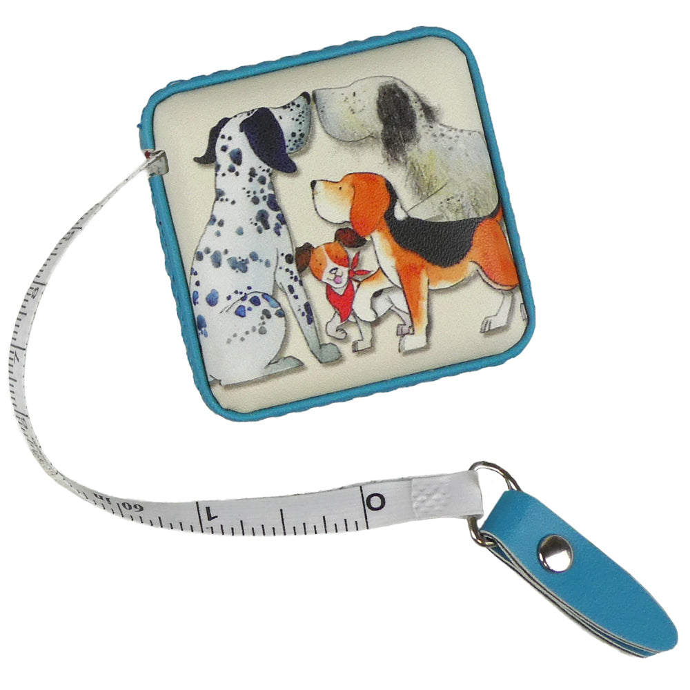 Quadratisches Maßband mit türkisem Rand und Aquarell-Illustration von Emma Ball: Dalmatiner, Beagle und kleiner Hund mit rotem Halstuch. Maßband ausgezogen mit Zentimeter- und Inch-Skala.