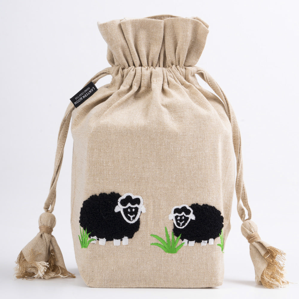 Verschiedene Farben der Meadow Drawstring Bag: Naturweiß, Rot, Schwarz und Gold.