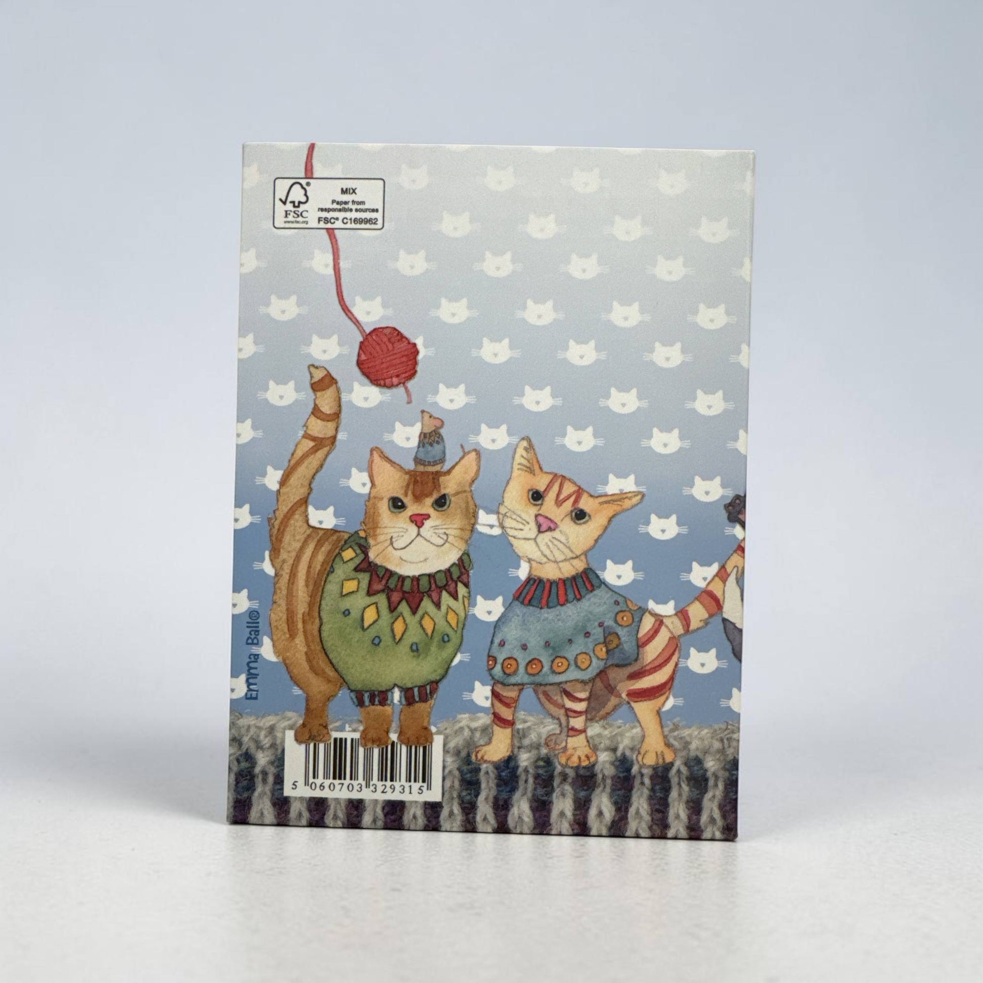 Rückseite des Notizbuchs „Kittens in Mittens" von Emma Ball — zwei Katzen in Strickpullovern auf grauem Hintergrund mit Katzenmuster-Motiv; eine hält ein rotes Wollknäuel hoch; FSC-Zertifizierungslogo oben links sichtbar.